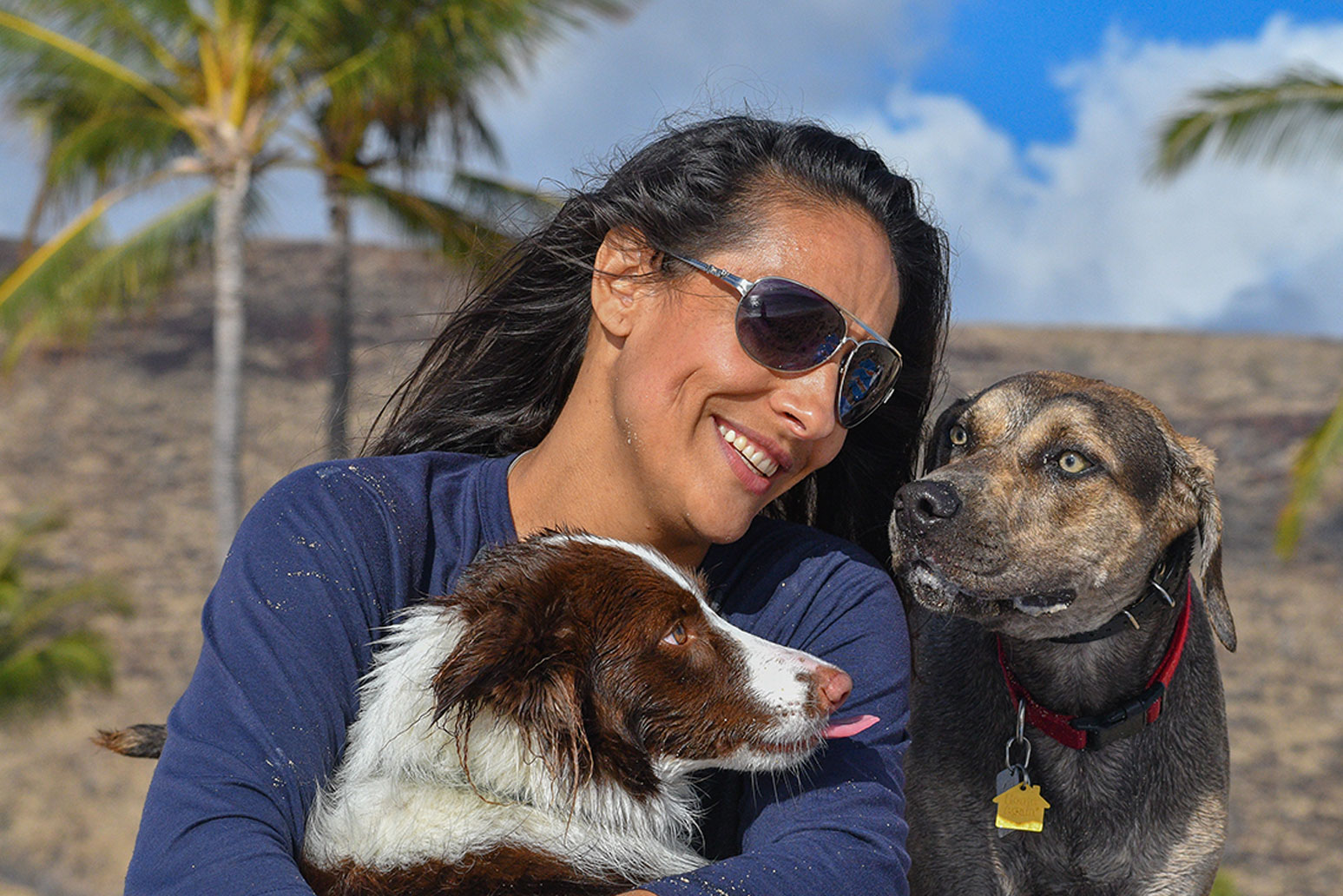 Maria with two dogs on the beach in Hawaii