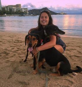 Dog trainer Alex with two dogs on the beach