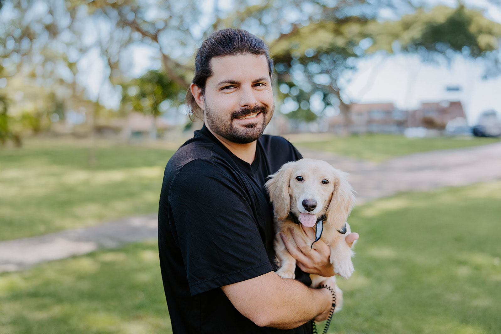 Ryan holding a dog at a park in Hawaii